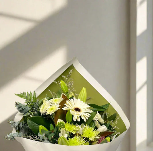 Elegant bouquet of white gerbera daisies and green chrysanthemums wrapped in white and green paper