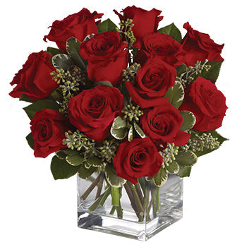 Bouquet of red roses in a clear glass vase on a white background