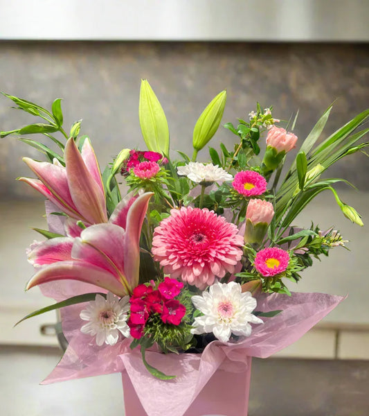 Pink and white mixed flower bouquet with lilies and chrysanthemums in a pink wrapper