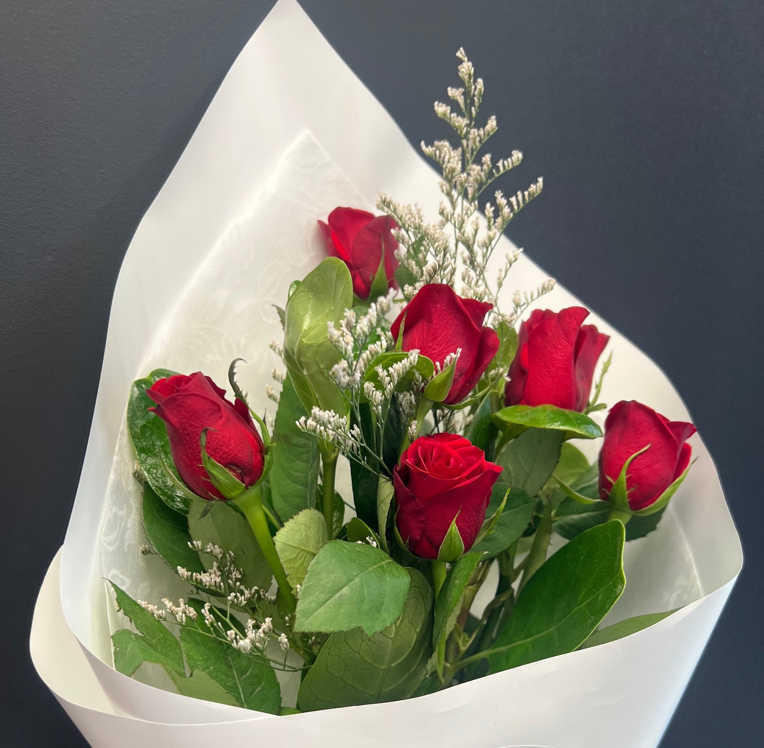 Bouquet of red roses wrapped in white paper