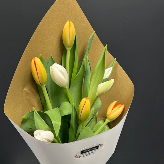 Bouquet of yellow and white tulips in brown and white paper