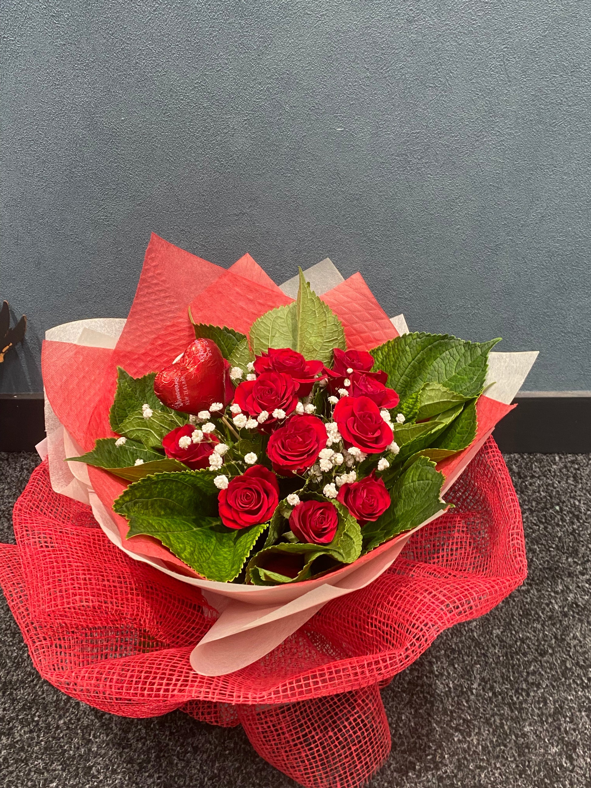 Bouquet of red roses with green leaves