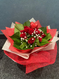 Bouquet of red roses with green leaves